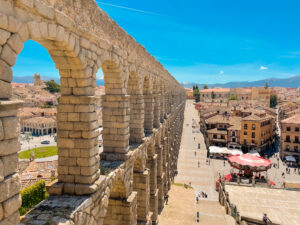 This original color photograph is of the Aqueduct of Segovia in Spain, framed by a deep blue sky, taken on a sultry, May day.