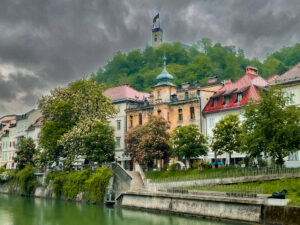 Ljubljana Castle with Breg Embankment on the Ljubljanica River, surrounded by spring greenery
