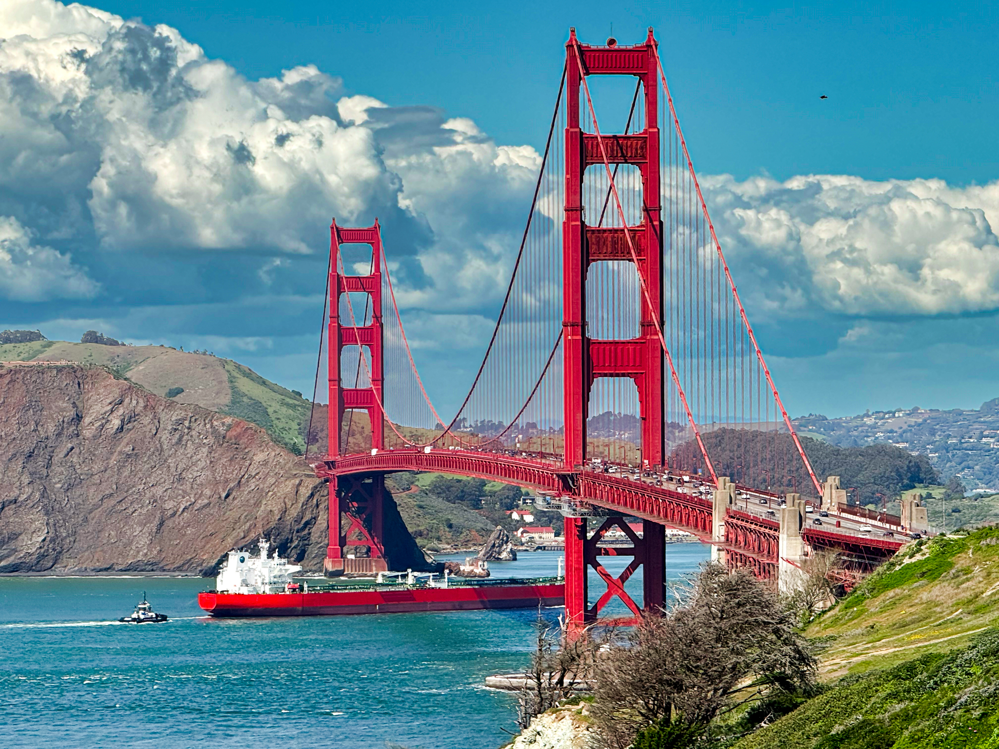 Golden freighter passing beneath the Golden Gate Bridge.